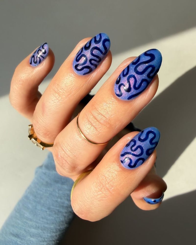 purple cat eye nails with swirly nail art design