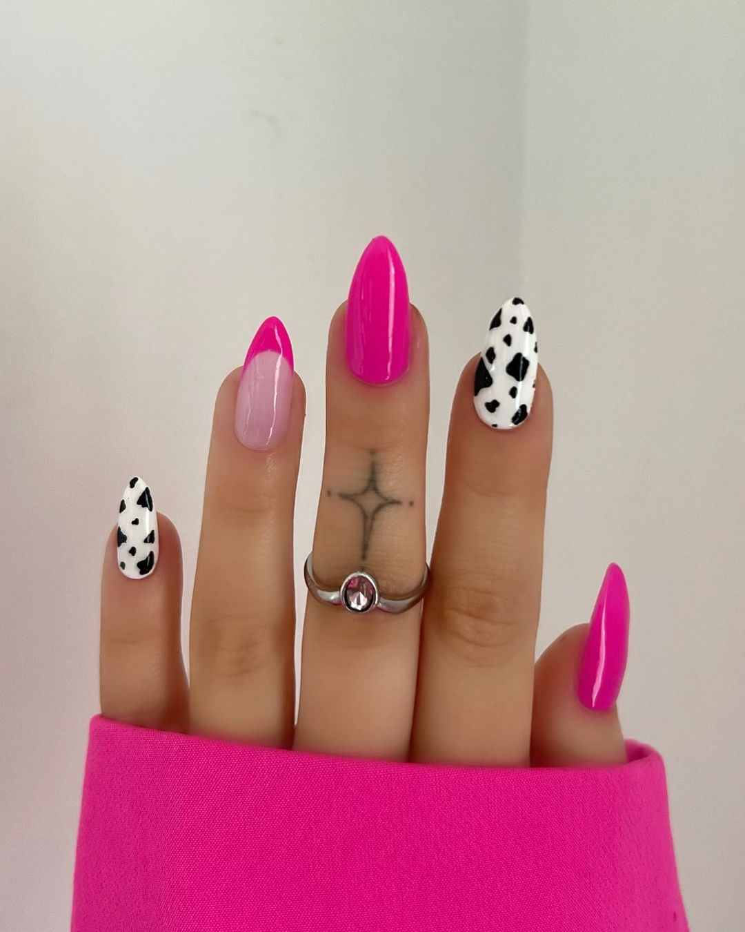Cow print nails with bright pink accents