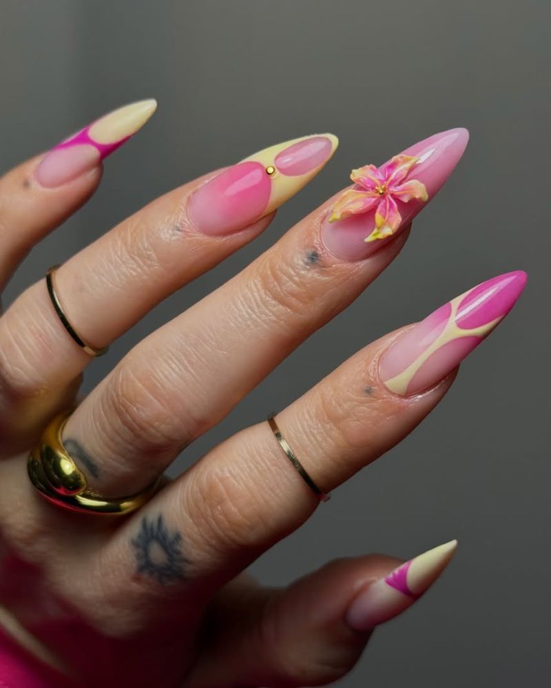 long stiletto nails with pink and yellow nail art and a 3d flower