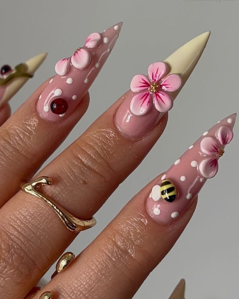 long stiletto nails with pastel yellow tips and cherry blossom 3d flowers