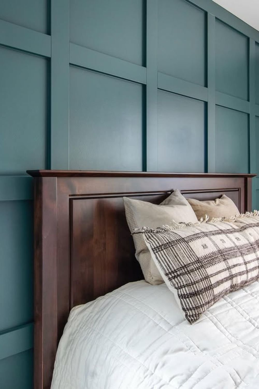 Rich teal grid wall behind a dark wood headboard