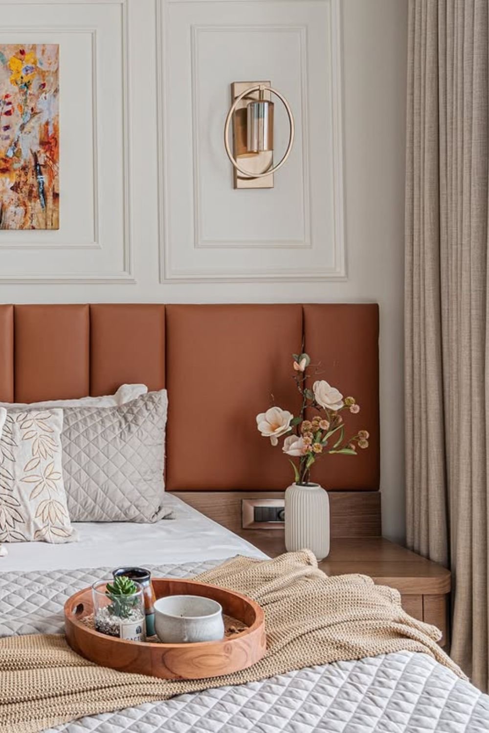 Framed panel trim behind a bed in soft neutral tones