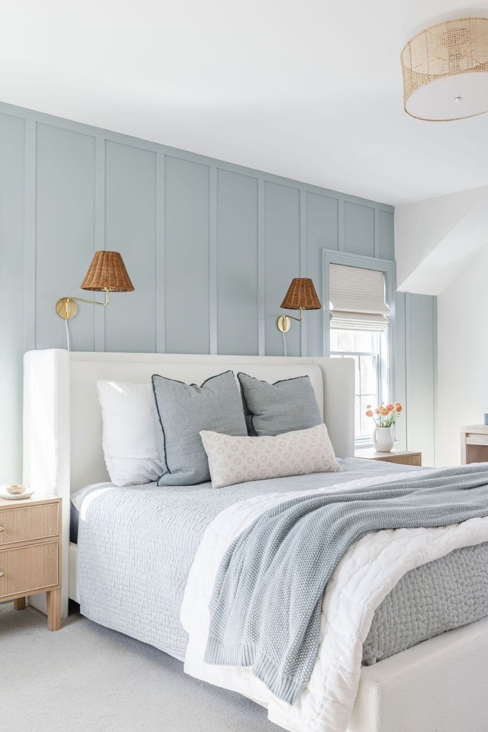 Sky blue vertical panels behind a bed with woven textures