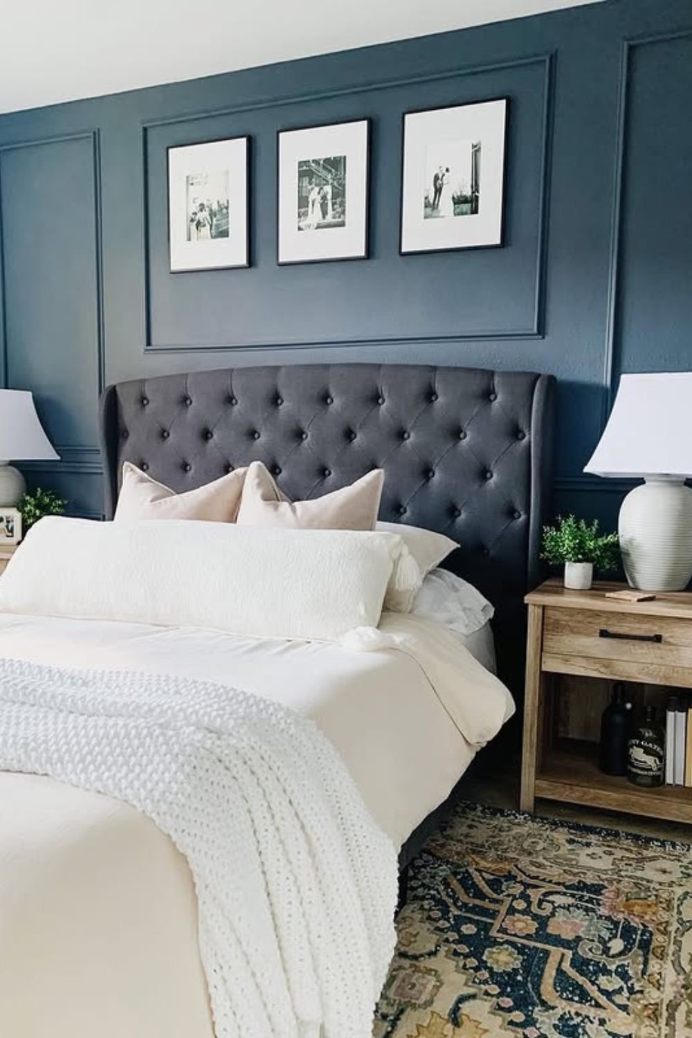 Picture-frame navy trim wall with tufted headboard and lamps