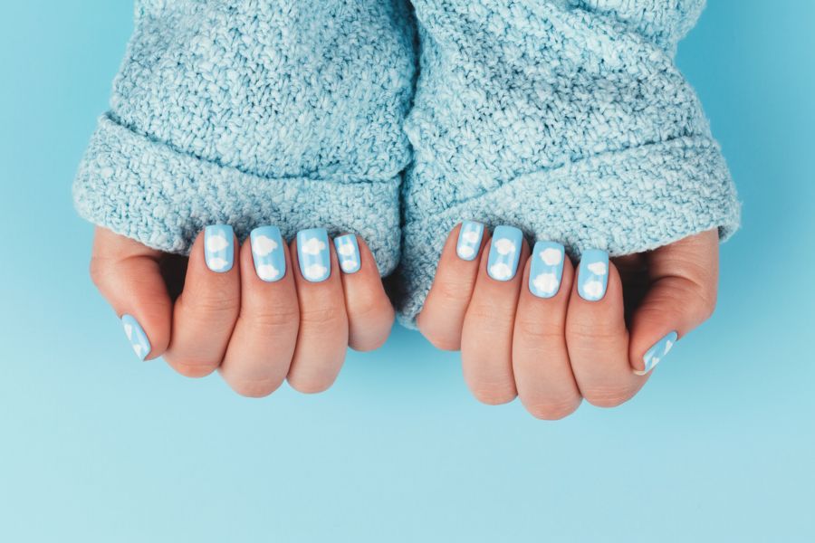 Baby blue square nails featuring soft white cloud designs for a dreamy sky-inspired look.
