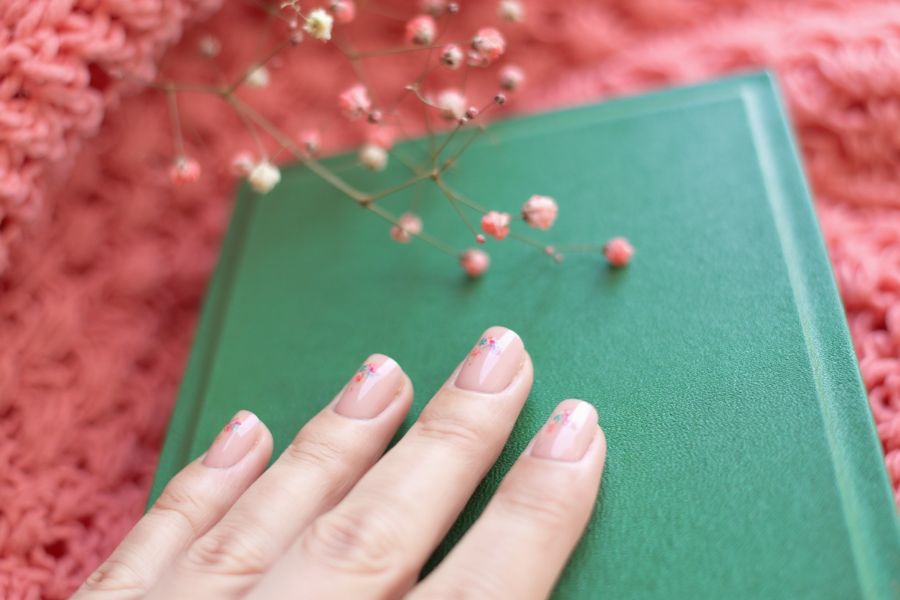 Beige square nails adorned with delicate pastel floral clusters for a soft, spring-inspired look.