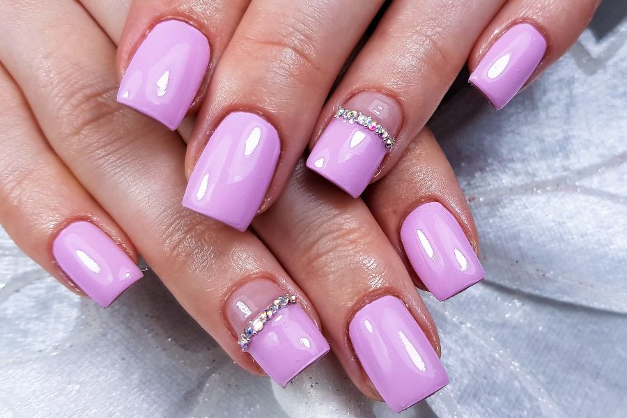 Blush pink square nails accented with delicate rhinestones for a chic, elegant touch.