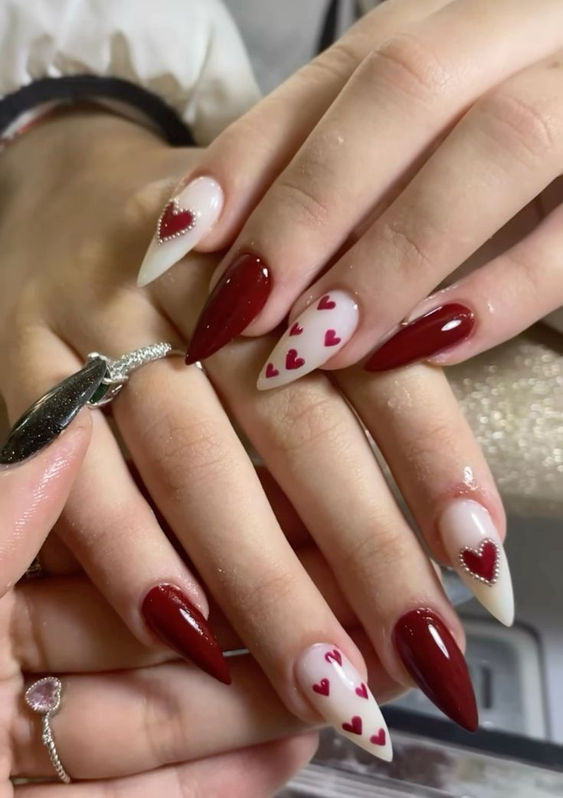 12. Romantic Elegance: Deep Red and Heart-Accented Valentine’s Day Nails