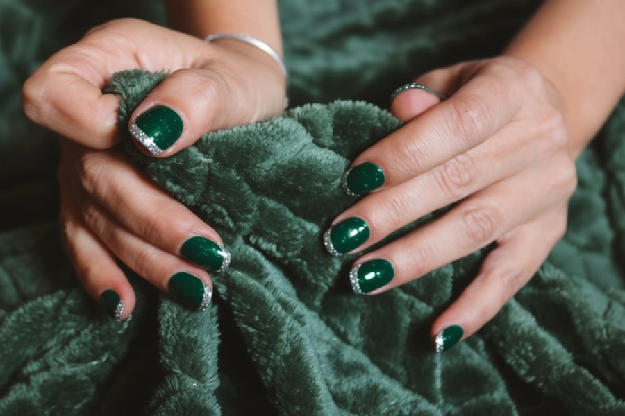 Emerald green square nails with sparkling silver glitter tips for a glamorous finish.