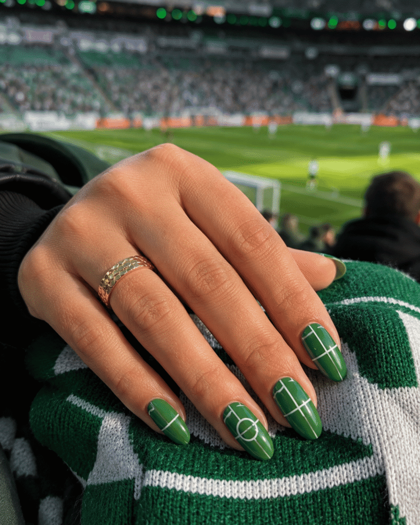 Green football field nails featuring soccer pitch inspired nail art with white field markings and glossy finish.