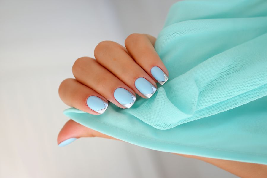 Icy blue square nails featuring metallic silver geometric tips for a sleek, modern look.