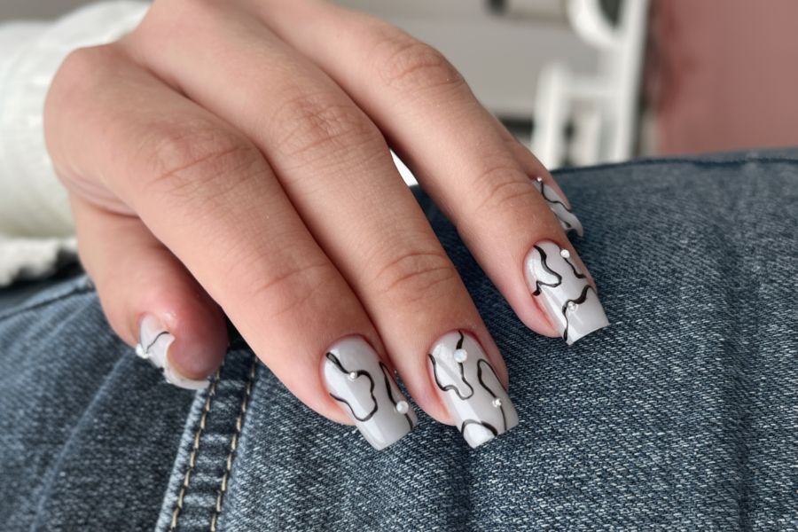 Light grey square nails featuring delicate white abstract lines for a clean, modern look.