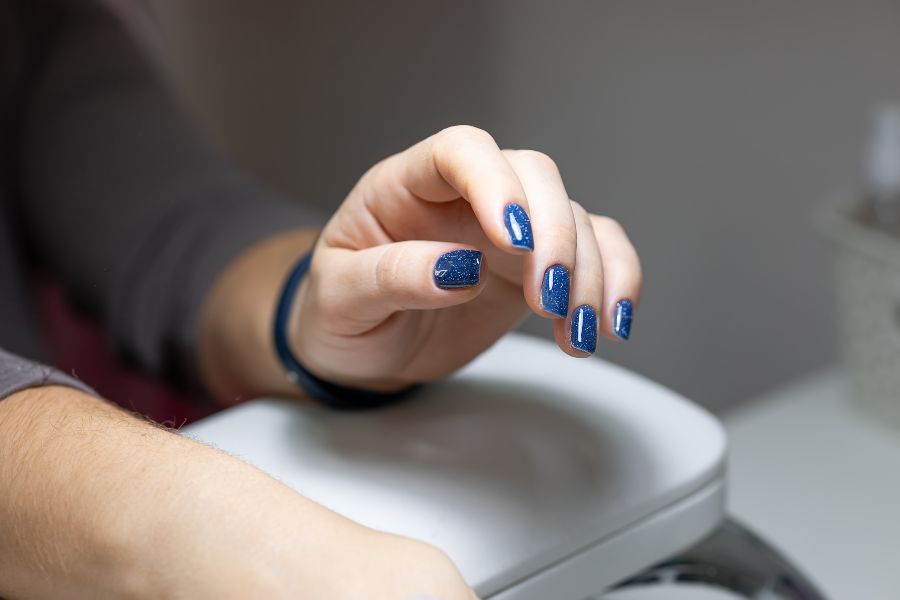 Midnight blue square nails with subtle silver star-like glitter for a celestial look.