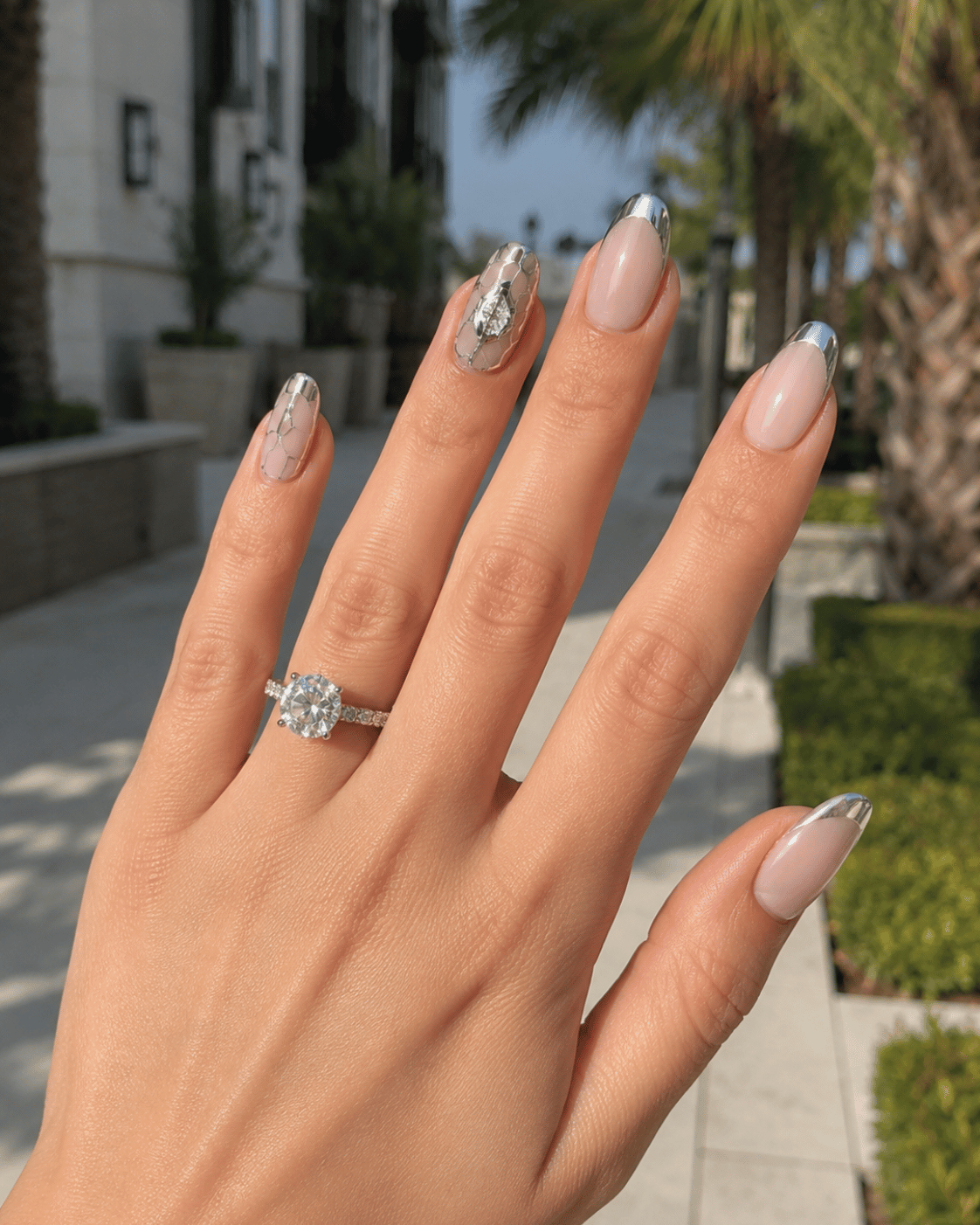 Modern chrome football nails featuring reflective silver accents and minimalist soccer-inspired nail art on almond-shaped nails.