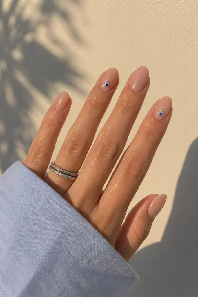 Nude Almond Nails with Evil Eye Accent