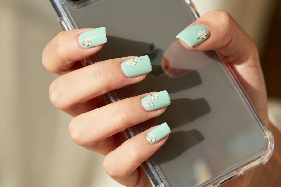 Pale mint square nails with delicate tiny floral details for a soft, feminine finish.
