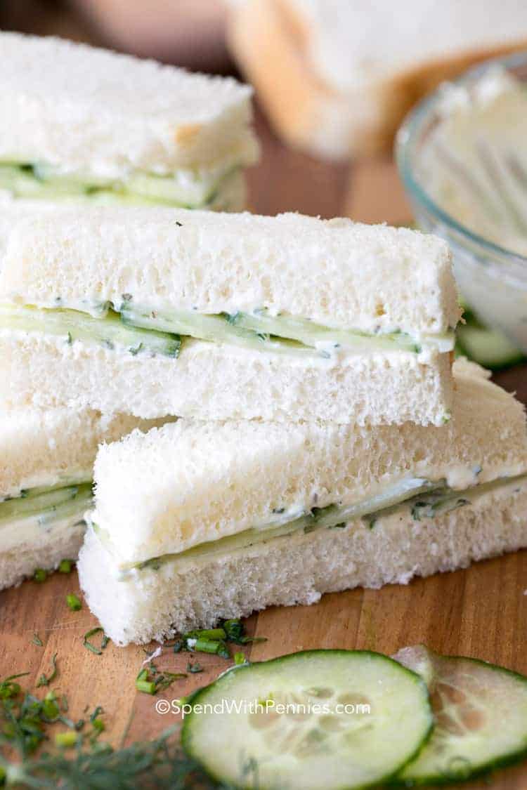 Cucumber Sandwiches on a wooden board with cucumber and dill