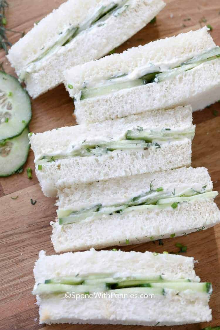 Cucumber Sandwiches cut in half on a wood board