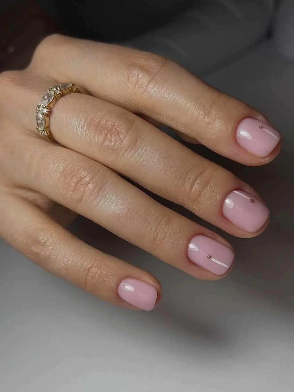 Ballet pink simple nail design on short square nails with small gold rhinestone accents