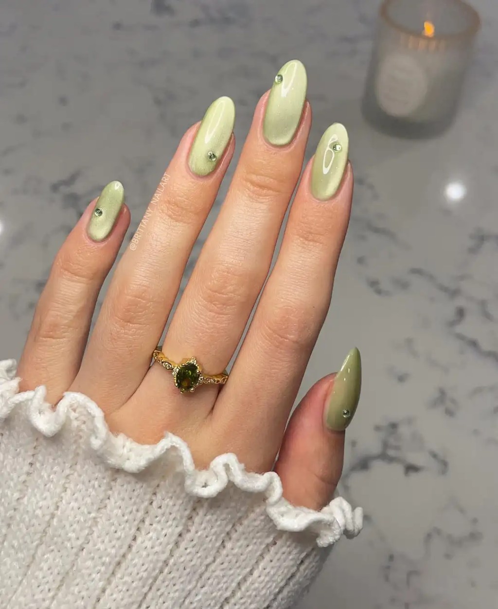 Sage green cat eye simple nail design on almond nails with small rhinestone accents