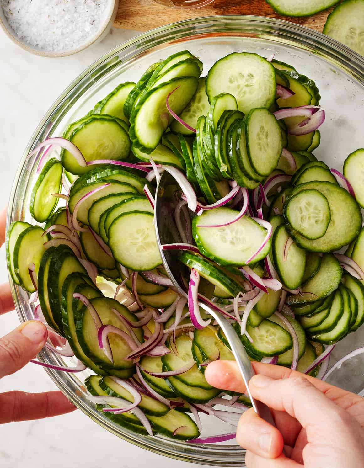 How to make cucumber salad - tossing cucumbers and onions in mixing bowl