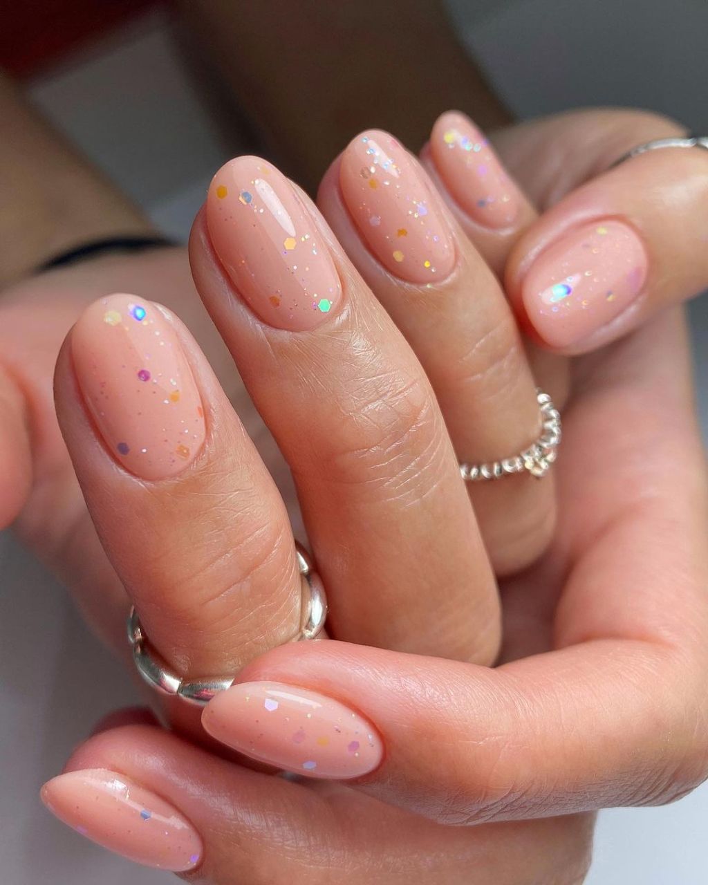 cute short simple manicure with a trendy glitter confetti top coat