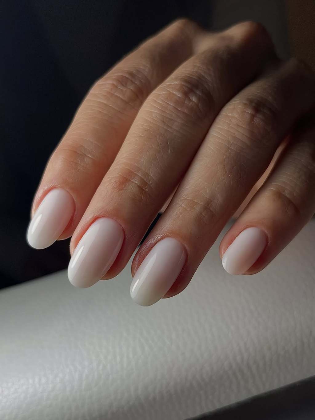 Milky white glazed simple nail design on medium almond nails with a high-gloss finish