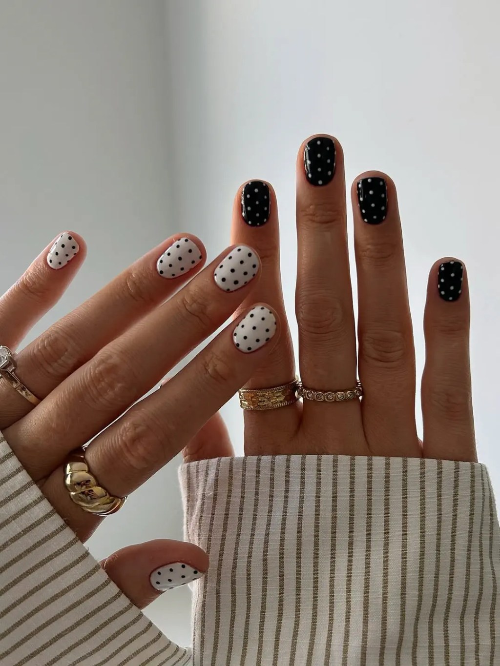 Mismatched black and white polka dot simple nail design on short square nails