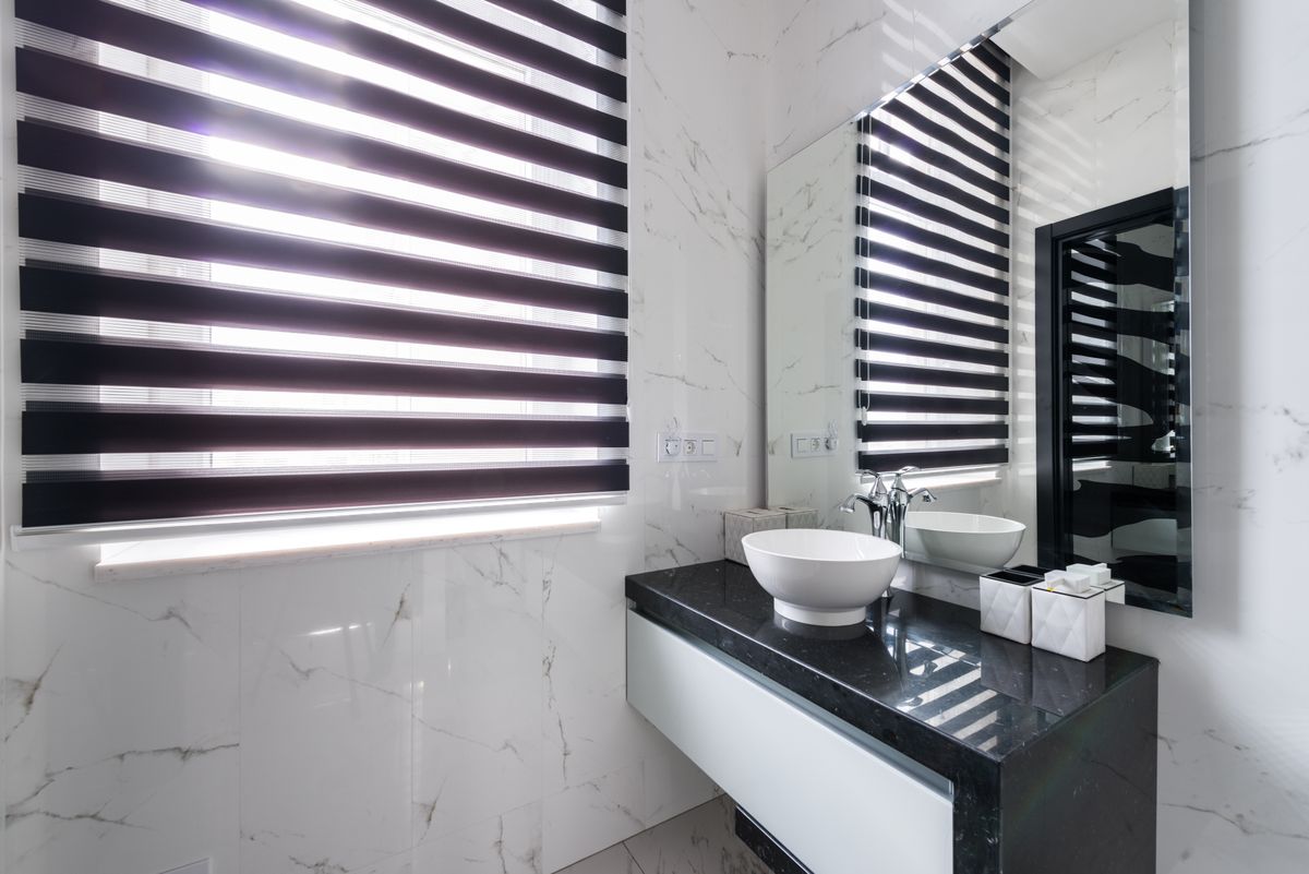 Spa-inspired coastal bathroom with a large mirror and soft daylight
