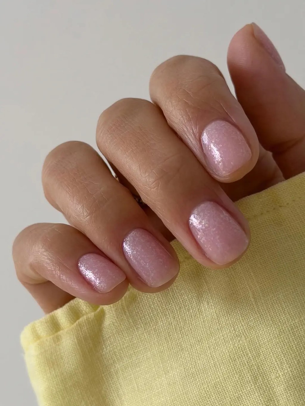 Short square nails with an iridescent pink shimmer finish