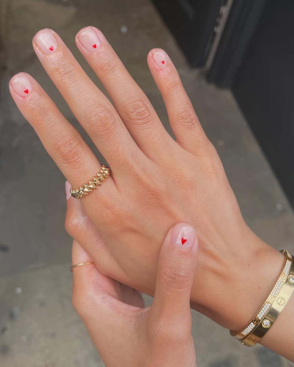 short nails with a clear gloss and tiny red hearts