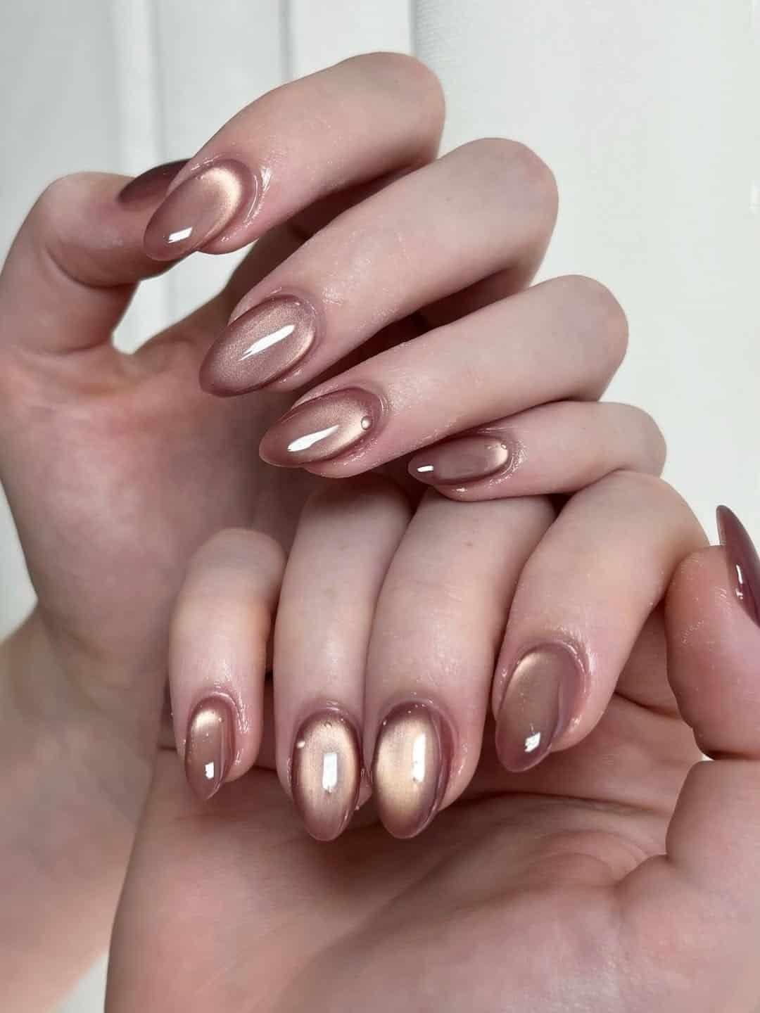 glossy rose gold cat eye summer nails with a metallic magnetic shimmer on oval tips.