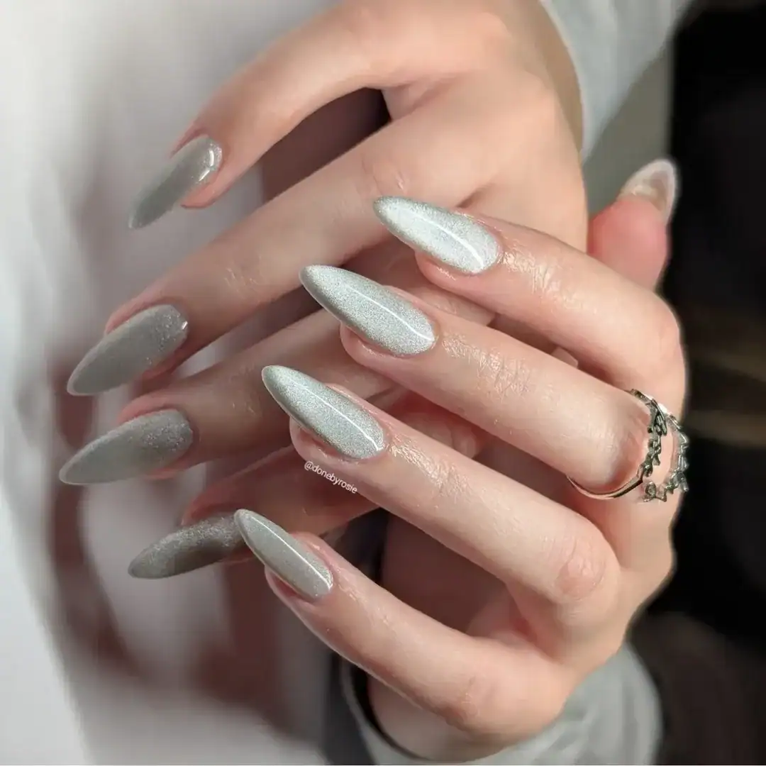 shimmering silver cat eye summer nails on long stiletto shapes with a metallic finish.